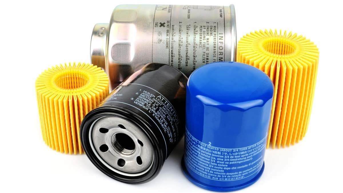 Multiple automotive filters, including blue and black spin-on canisters and yellow pleated cartridge filters.